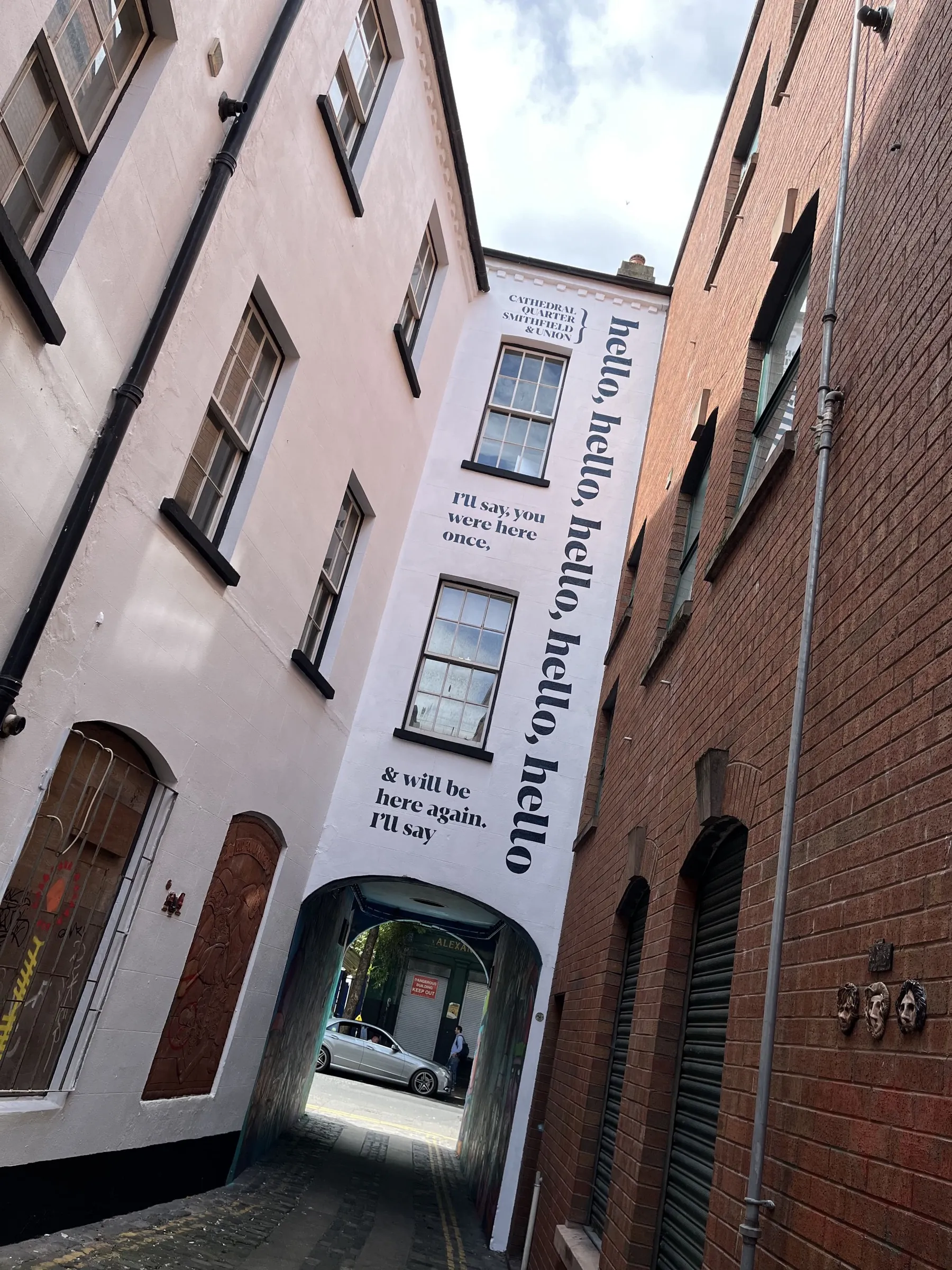 The Exchange Place gable seen from the alley, the poem running up its full height.