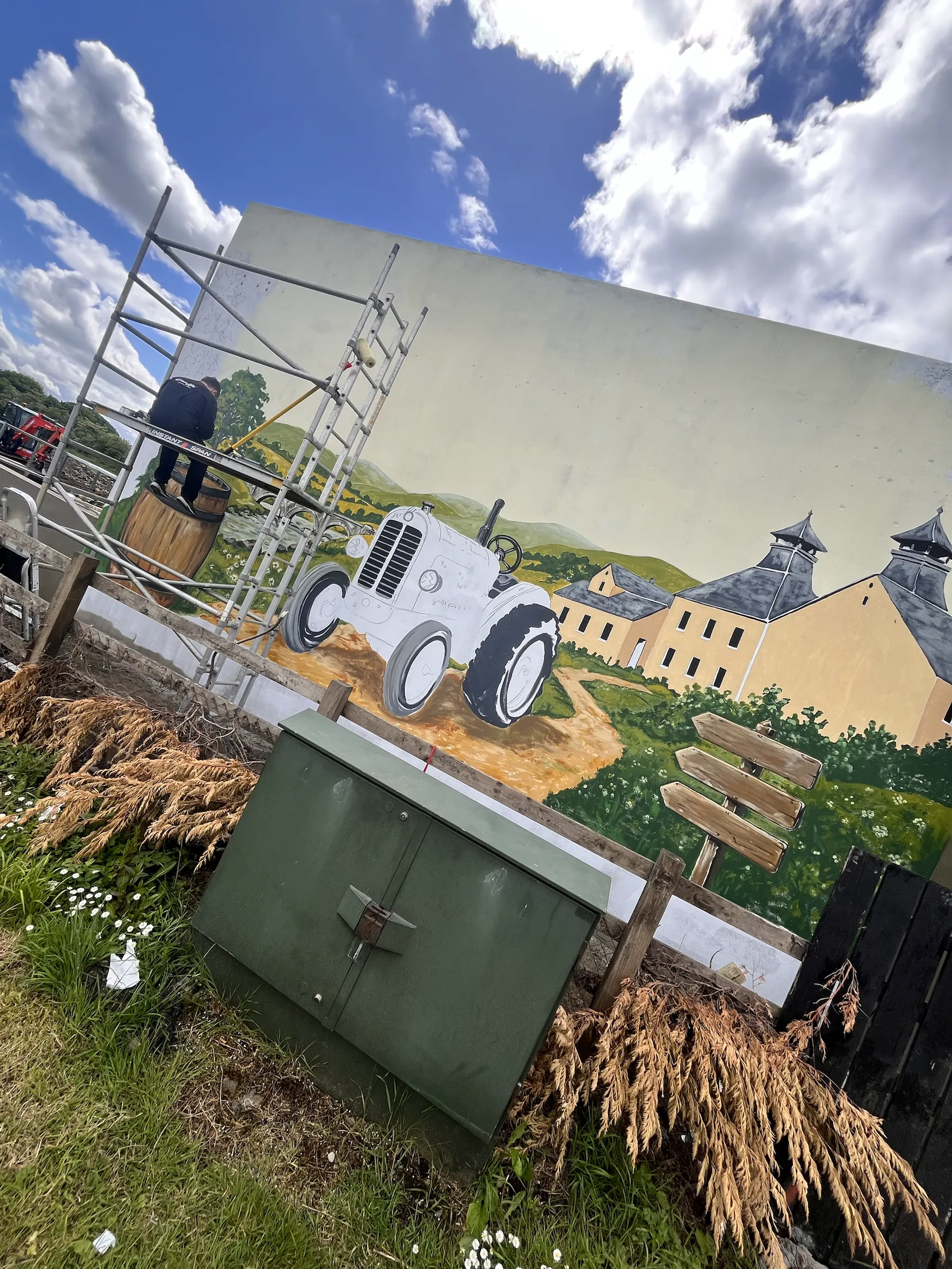 The grey tractor and Bushmills distillery painted on the gable, scaffolding still up at one end.
