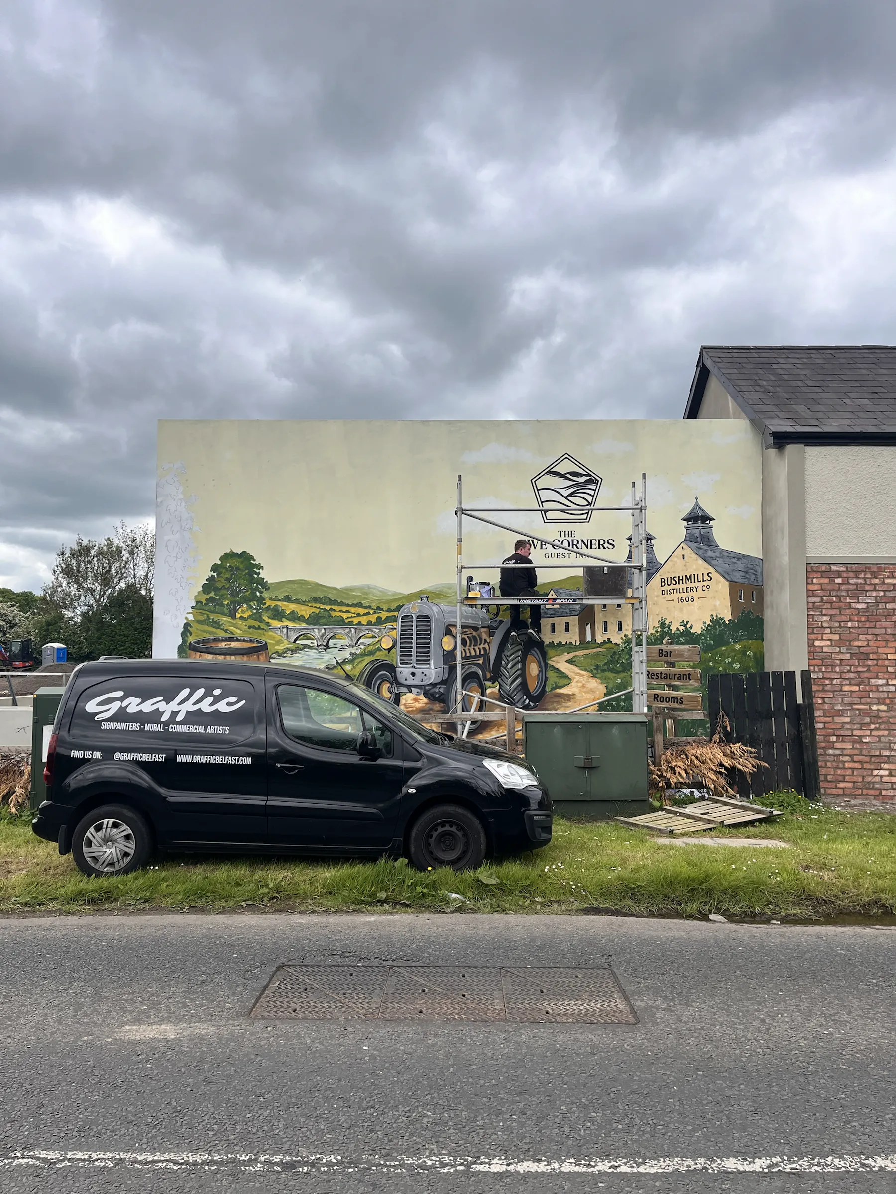 A Graffic van parked in front of the nearly finished Bushmills mural.