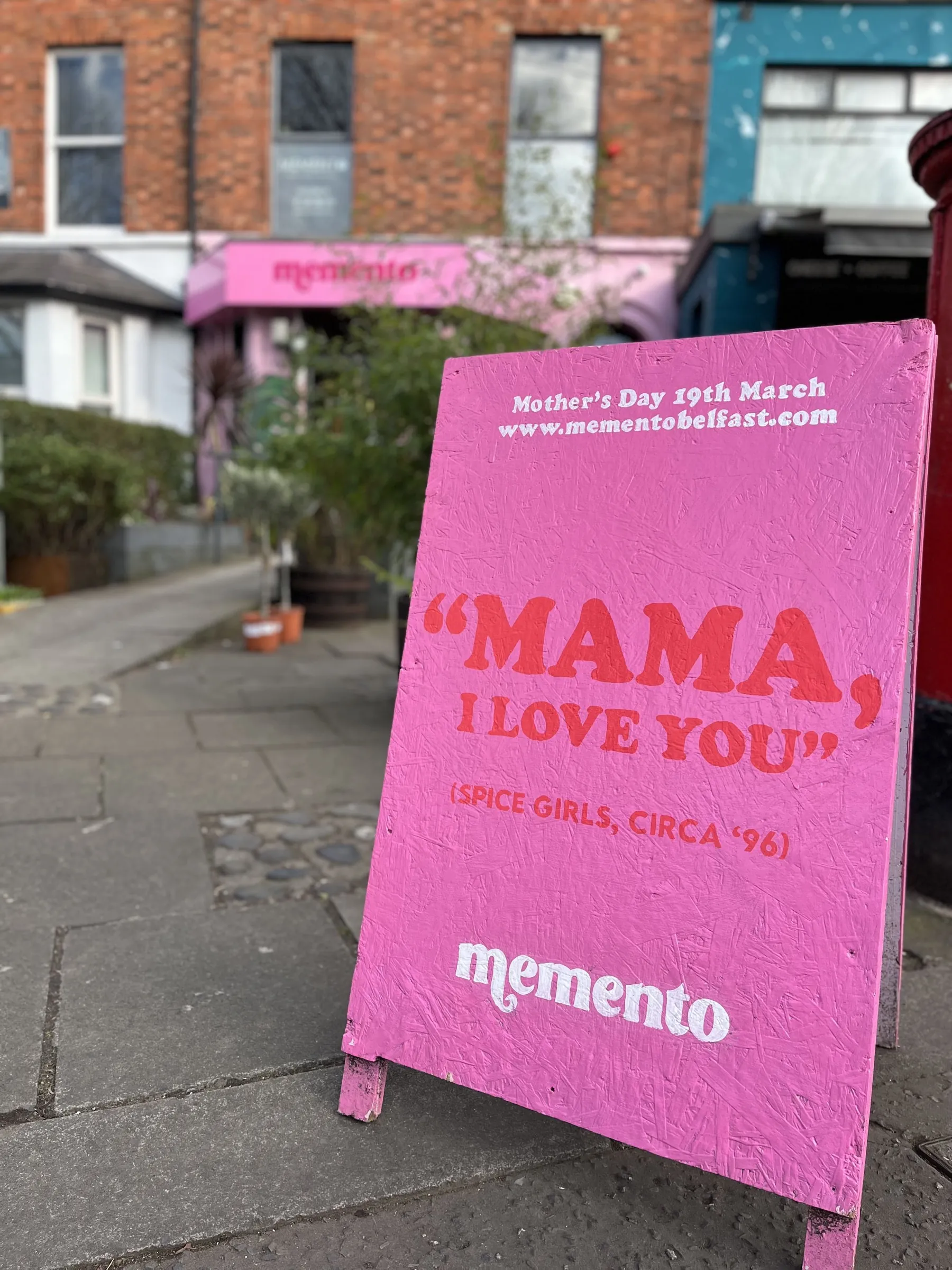 A pink Memento A-board painted with “Mama, I love you” for Mother’s Day.