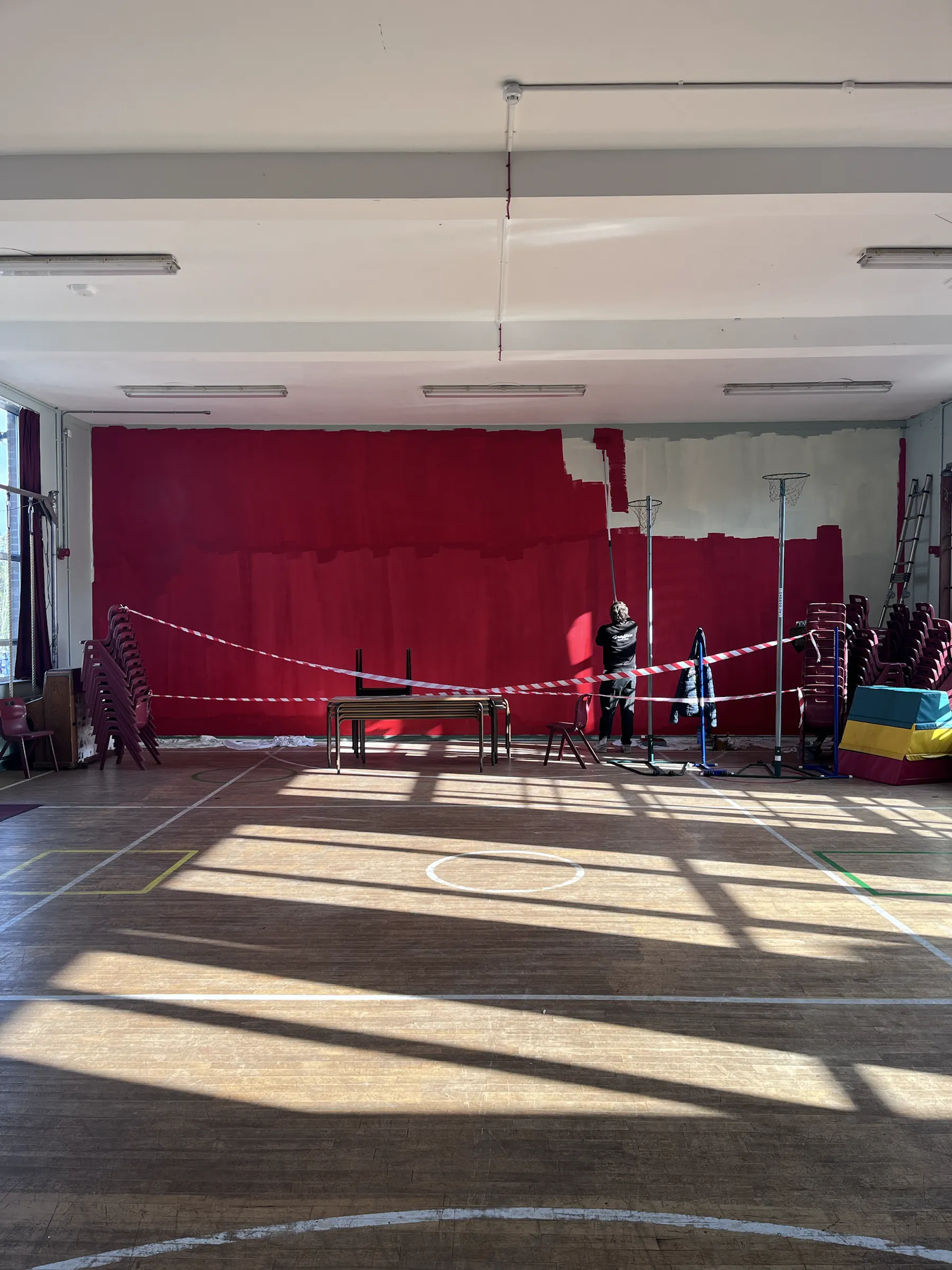 The school hall before work began, taped off in front of the stage.
